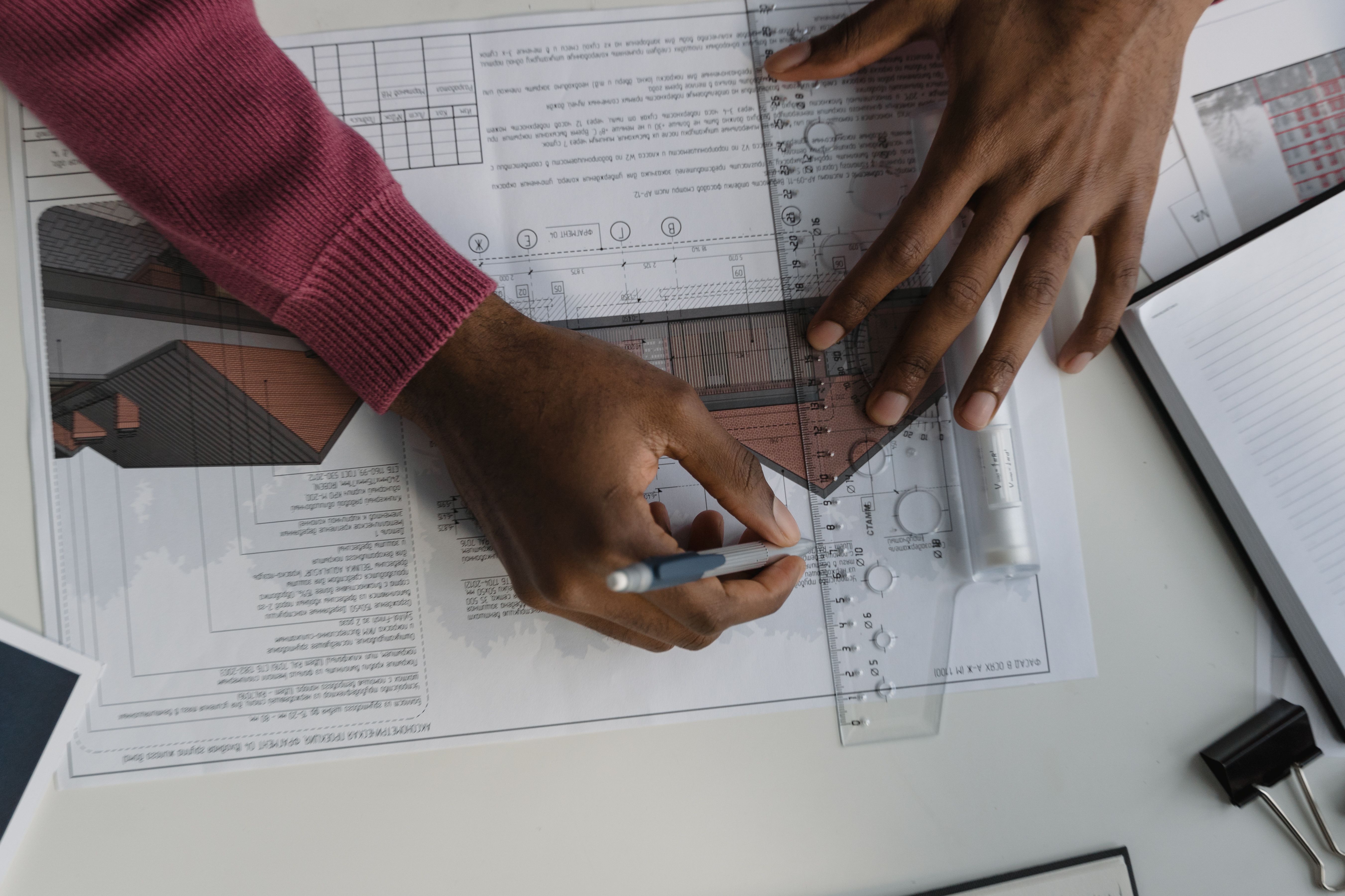 Hands reviewing architectural blueprints and building plans