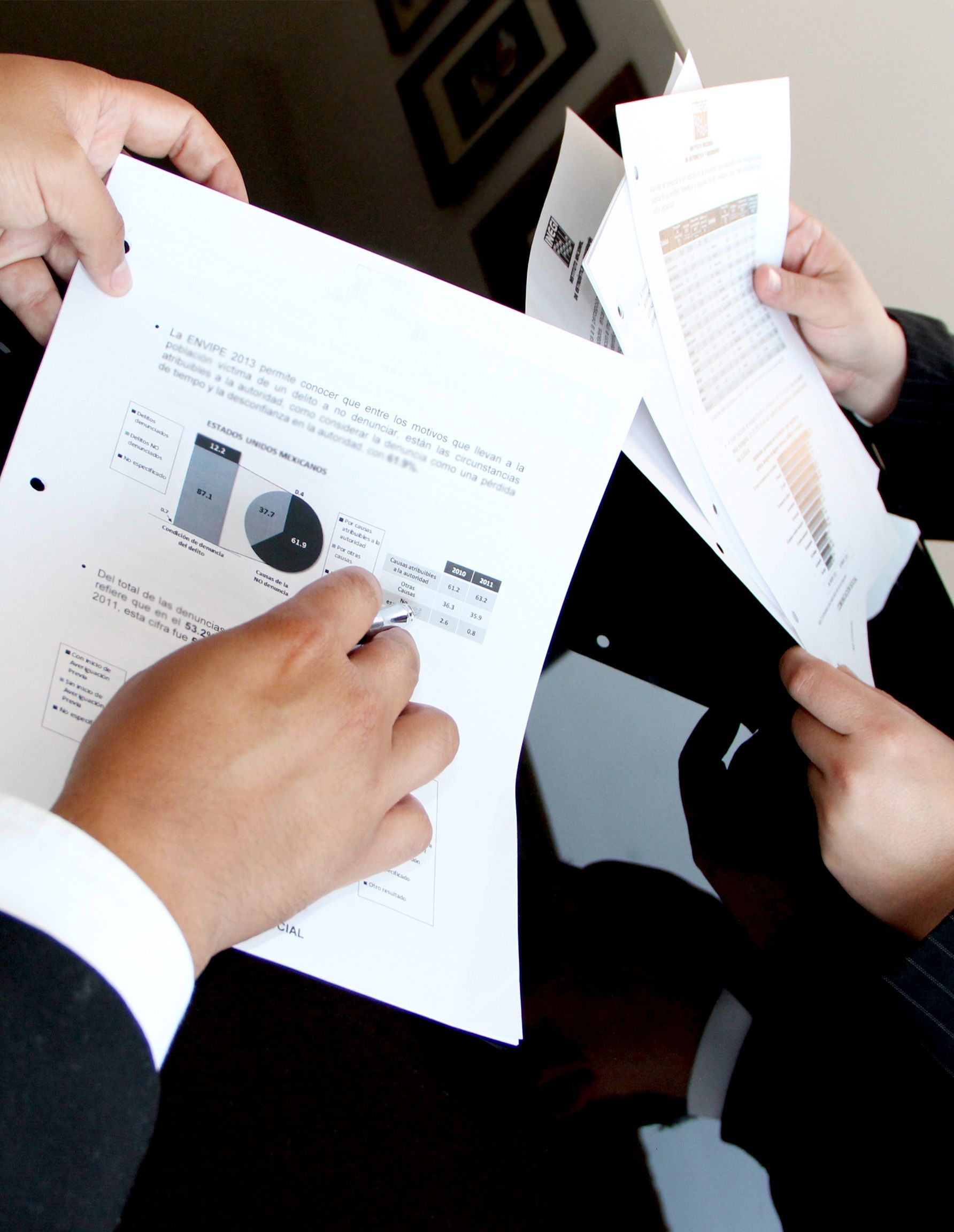 Executives reviewing printed data reports and charts together