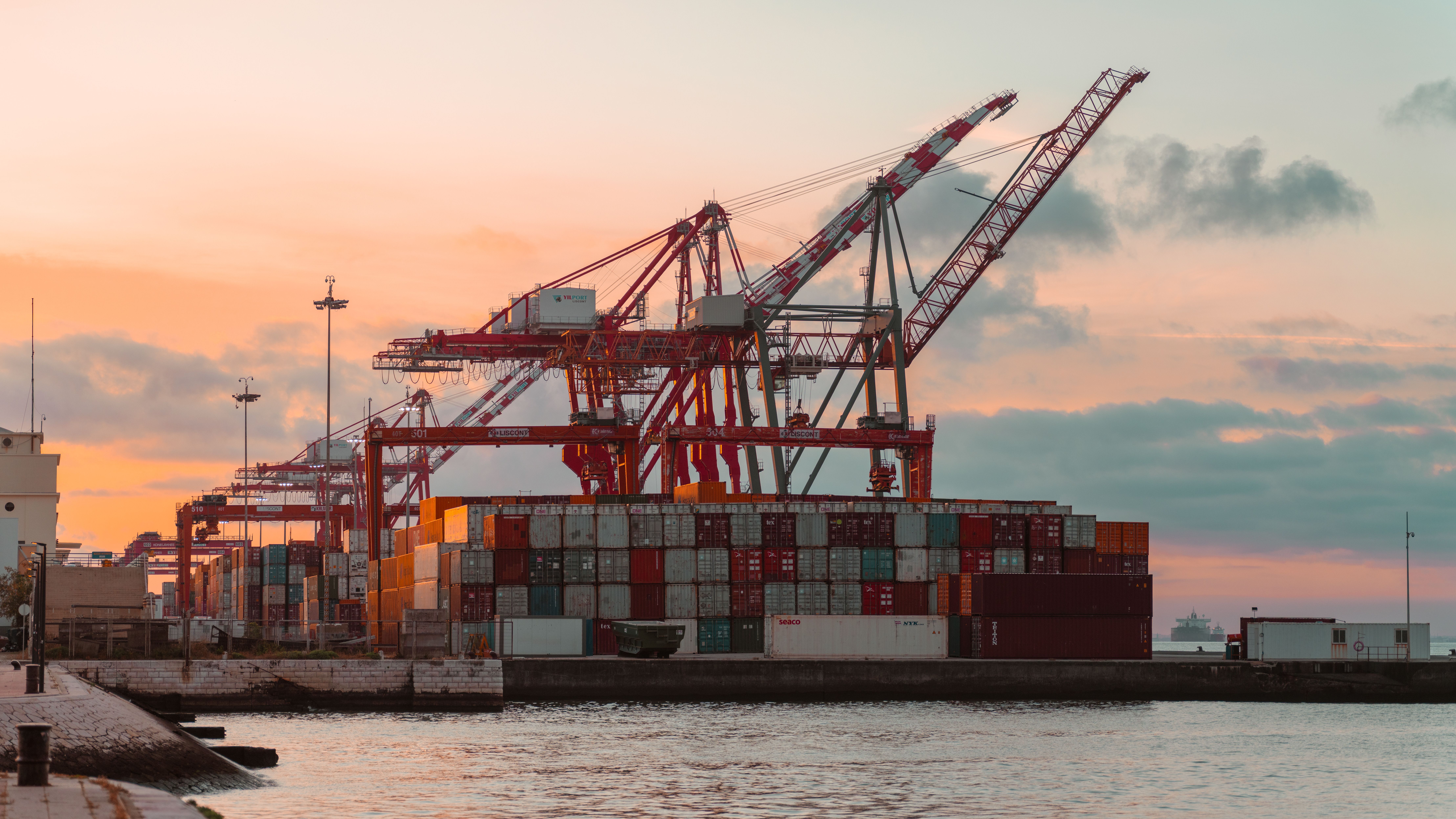 Container cranes at a shipping port at sunset